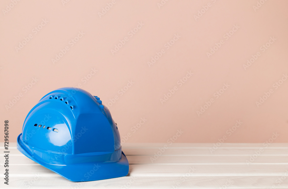 Fototapeta premium Blue construction helmet on wooden table