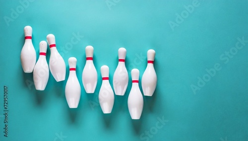 minimalist photo of bowling pins over turquoise blue background flat lay top down image of white bowling pins with copy space photo