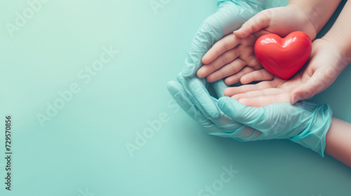 Doctor hands with medical gloves holding child hands and red heart, health insurance, organ donation