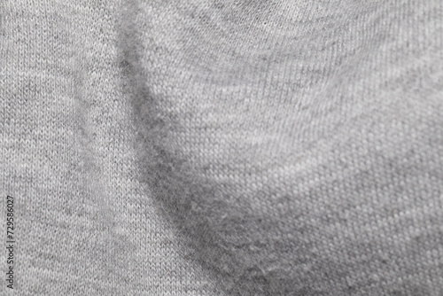 This image shows a close-up view of a gray knitted fabric, highlighting the intricate texture and weave pattern.