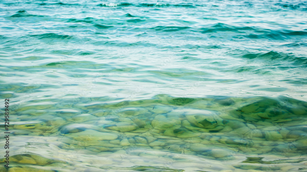 Clean transparent turquoise sea water, through which you can see pebbles on the bottom of the sea Clean transparent turquoise sea water, through which you can see pebbles on the bottom of the sea