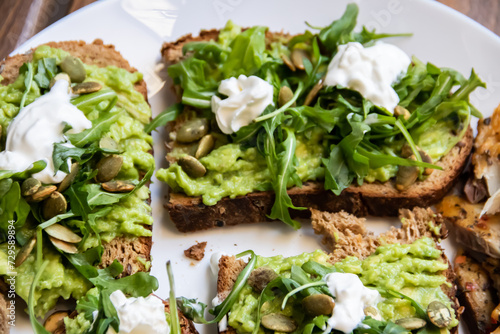 Smashed avocado on Toast with Labneh, Lemon, Parsley, Cheese, Edamame and different dried seeds, sunflower and pumpkin, very healthy and vegan green breakfast made by organic ingredients, healthy food