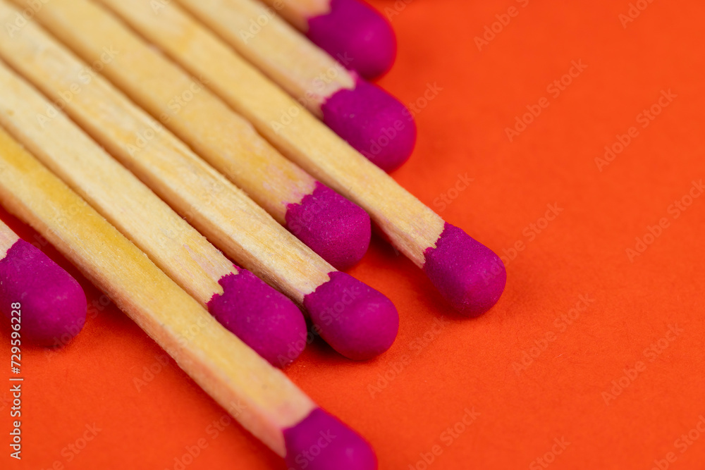 matches with a red pink substance for lighting on an orange background