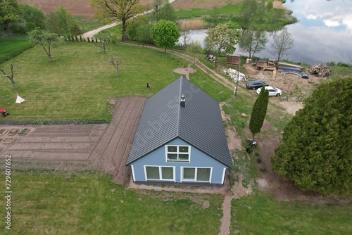 Wallpaper Mural Photo of a farmhouse by the river from the sky, a Scandinavian-style house is being built by the river in Lithuania Torontodigital.ca