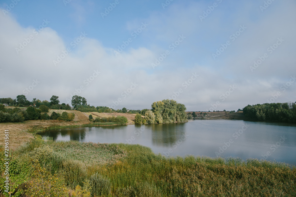A picturesque landscape with a pond near the village.
