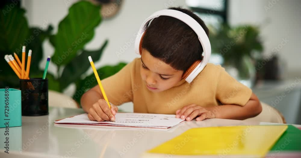 Child, headphones or pencil to learn writing with audio, relax or classical music for creativity in home school. Boy, learning alphabet and podcast tutor for language development and calm in kitchen Child, headphones or pencil to learn writing with audio, relax or classical music for creativity in home school. Boy, learning alphabet and podcast tutor for language development and calm in kitchen