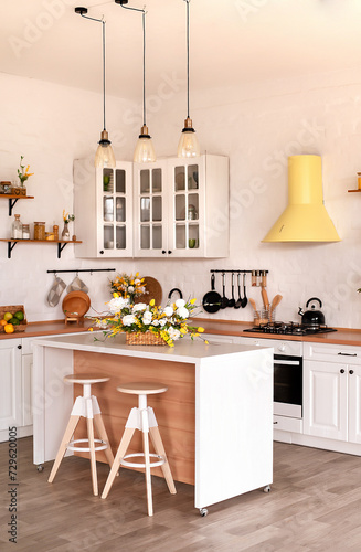 Fototapeta Naklejka Na Ścianę i Meble -  Modern Kitchen Interior with Island, Sink, Cabinets, and Big Window in New Luxury Home Decorated With Flowers
