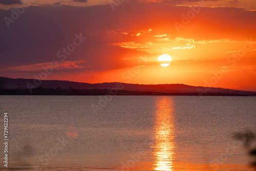 Incredible amazing, colorful summer sunsrise in Bulgaria Black coast. Orange sunset sky and reflection in the blue water.