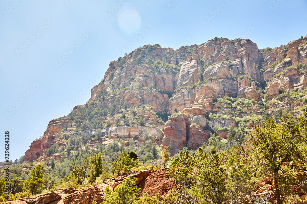 Sedona Red Rock Cliffs with Green Vegetation and Lens Flare