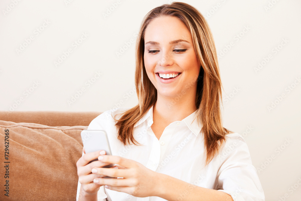 Young woman smiling at her smartphone Young woman smiling at her smartphone