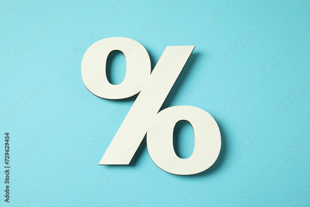White percent sign on light blue background, top view White percent sign on light blue background, top view