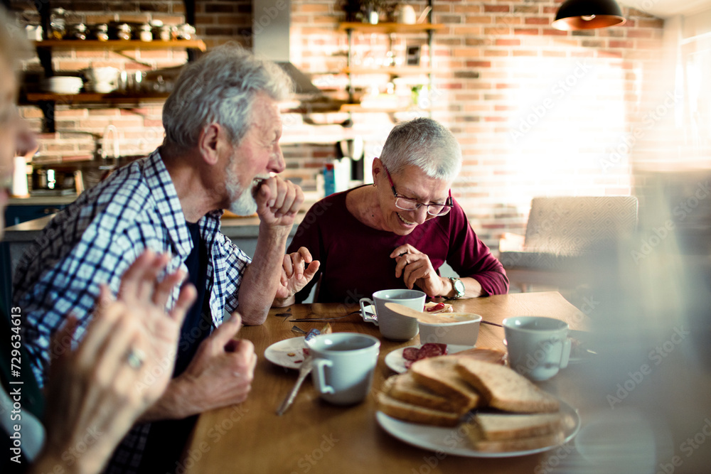 Smiling senior people having breakfast together at home Smiling senior people having breakfast together at home