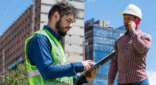 Wallpaper Mural  Workers at work looking some documents for a deal in construction site Torontodigital.ca
