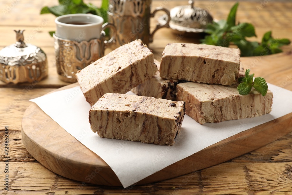 Tasty chocolate halva with mint on wooden table, closeup Tasty chocolate halva with mint on wooden table, closeup