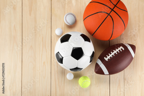 Many different sports balls on wooden background, flat lay. Space for text