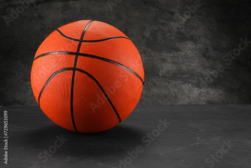 Basketball ball on dark gray background, space for text © New Africa