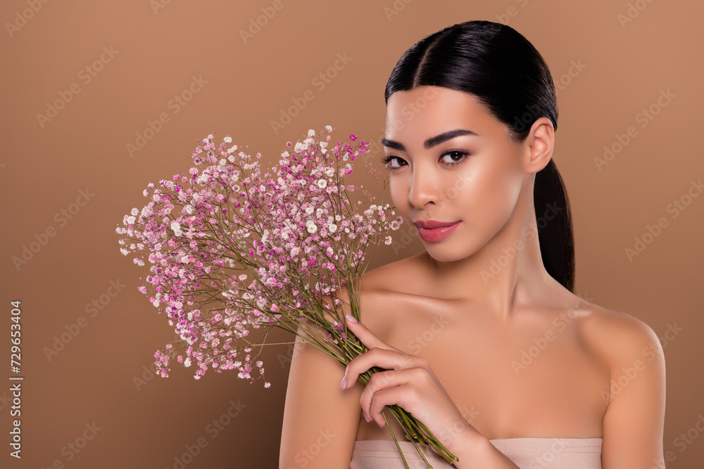 Portrait of lady pefect silky pure skin hand hold nice flowers herbal gel serum isolated on beige color background Portrait of lady pefect silky pure skin hand hold nice flowers herbal gel serum isolated on beige color background