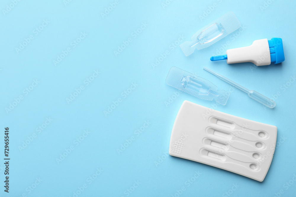 Disposable express test kit on light blue background, flat lay. Space for text