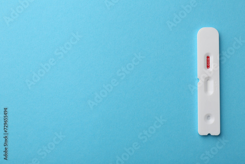 Disposable Covid-19 express test on light blue background, top view. Space for text