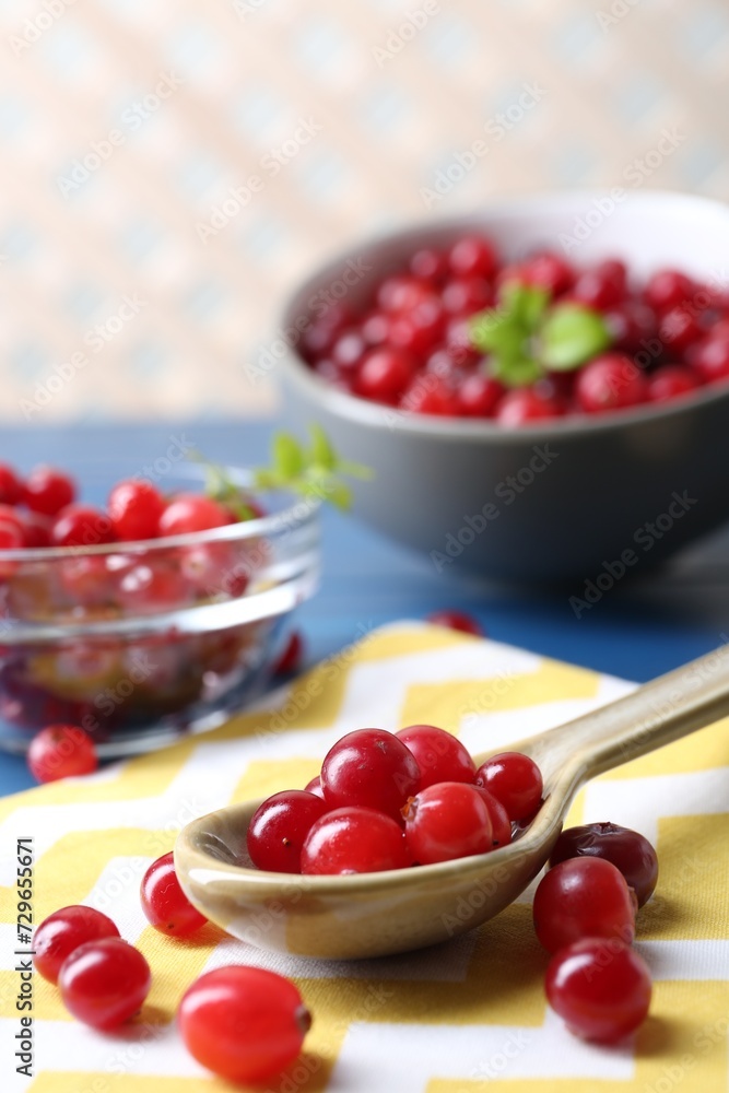 Spoon with fresh ripe cranberries on table, closeup Spoon with fresh ripe cranberries on table, closeup