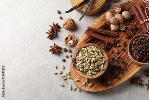 Fototapeta Naklejka Na Ścianę i Meble -  Different spices and nuts on light gray table, flat lay. Space for text