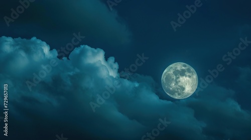  a full moon in a cloudy sky with a dark blue sky behind it and a few clouds in the foreground and a dark blue sky with a few white clouds in the foreground.