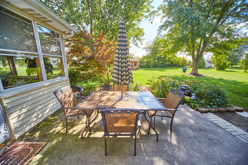 Suburban Backyard Oasis with Patio Dining Set and Garden Decor