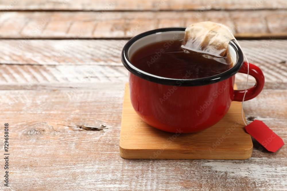 Tea bag in cup with hot drink on wooden rustic table. Space for text Tea bag in cup with hot drink on wooden rustic table. Space for text