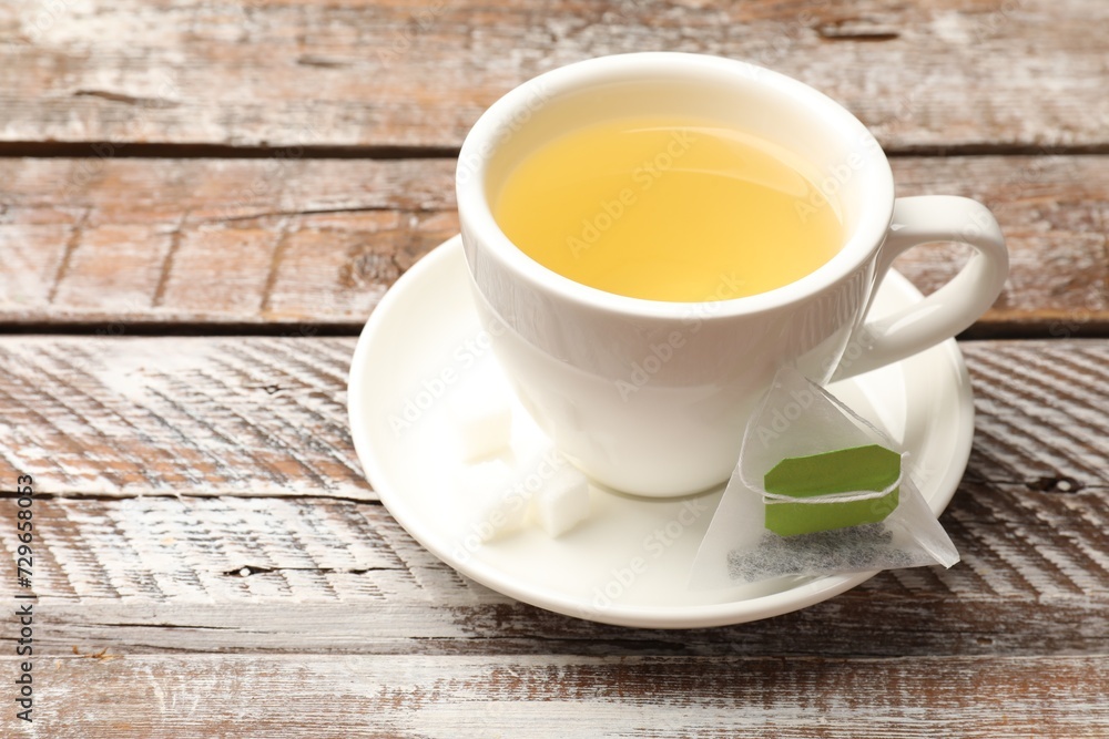 Tea bags and cup of aromatic drink on wooden rustic table, closeup. Space for text Tea bags and cup of aromatic drink on wooden rustic table, closeup. Space for text