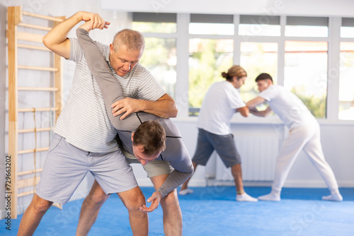 Male and senior man athletes during classes, training improve and practice wrestling with opponent in technique of martial arts. Work on yourself, increase endurance, determination, courage