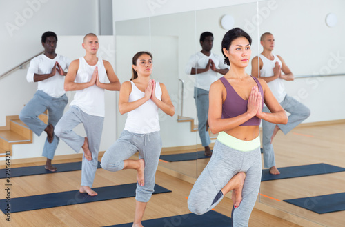 Fitness, sport and healthy lifestyle concept - group of people doing yoga at studio