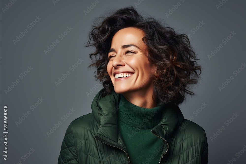 Smiling woman in warm clothes. Studio shot over grey background. Smiling woman in warm clothes. Studio shot over grey background.