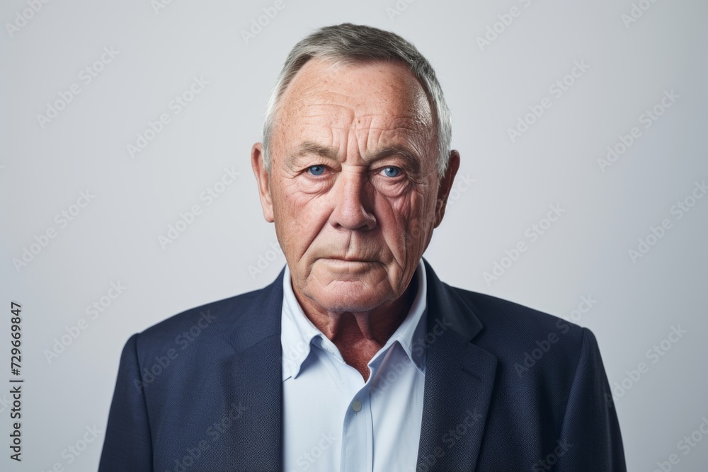 Portrait of a senior businessman looking at camera. Isolated on grey background. Portrait of a senior businessman looking at camera. Isolated on grey background.