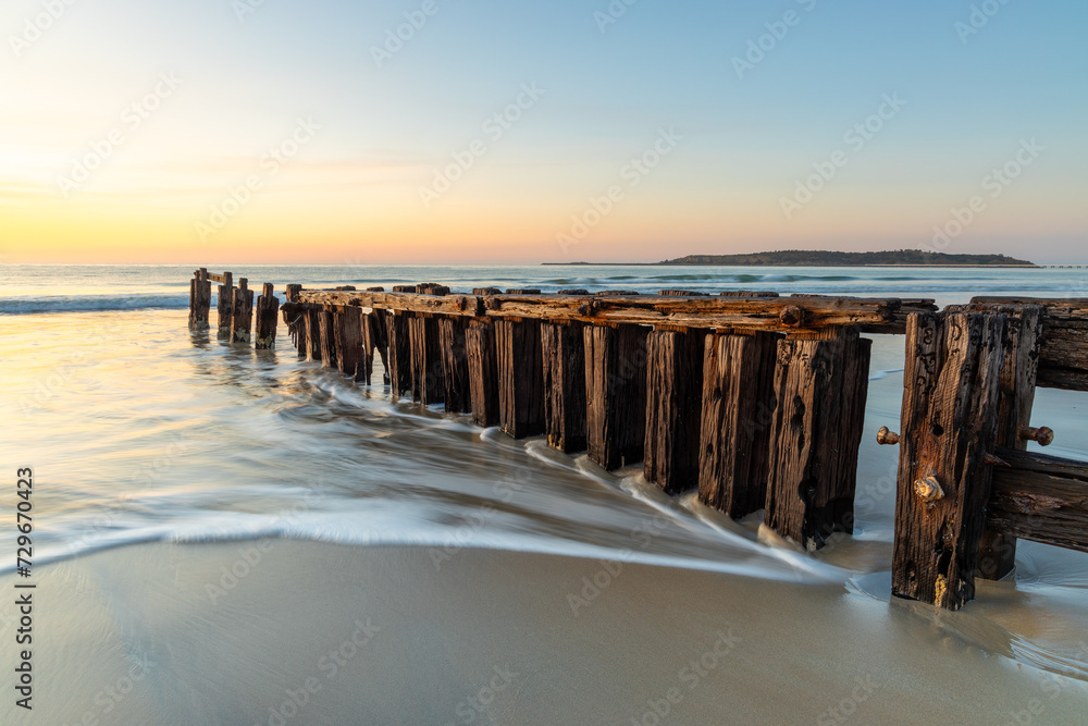 Obraz premium The Victor Harbor erosion groyne with a long exposure and granite island in background and pastel skies in South Australia on September 11th 2023
