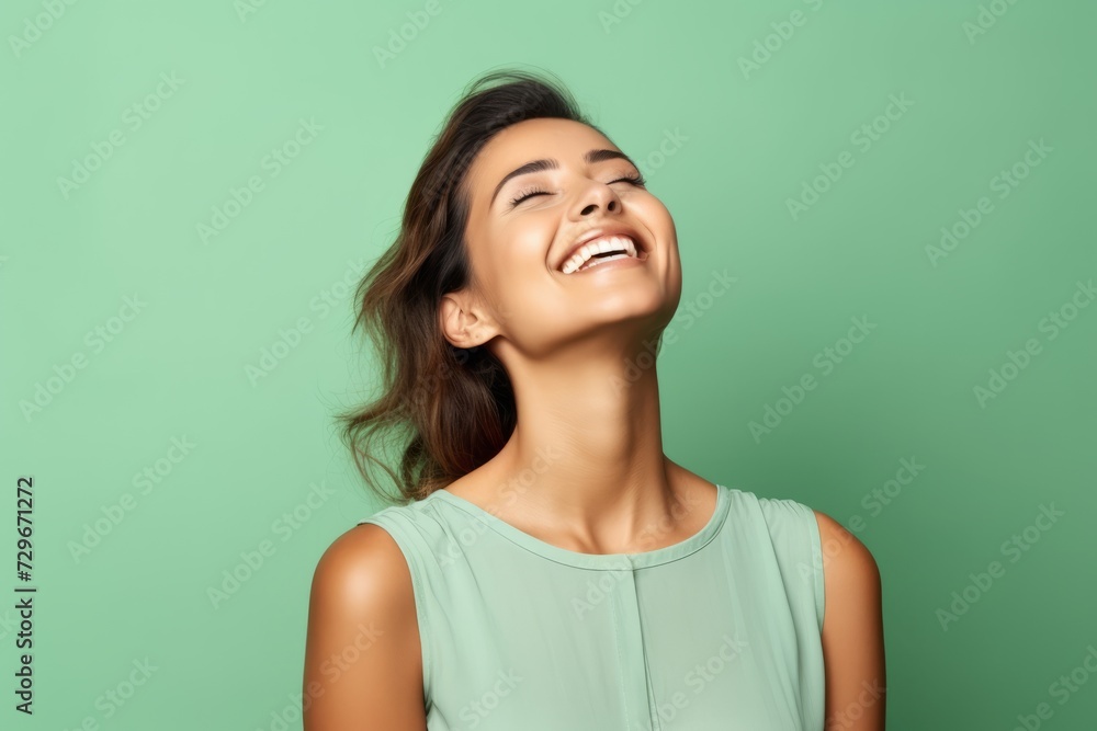 Beauty portrait of young happy smiling woman in green dress on green background Beauty portrait of young happy smiling woman in green dress on green background