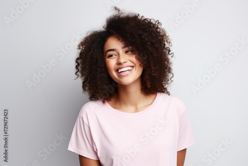 Young african american woman with afro hairstyle smiling. © Asier