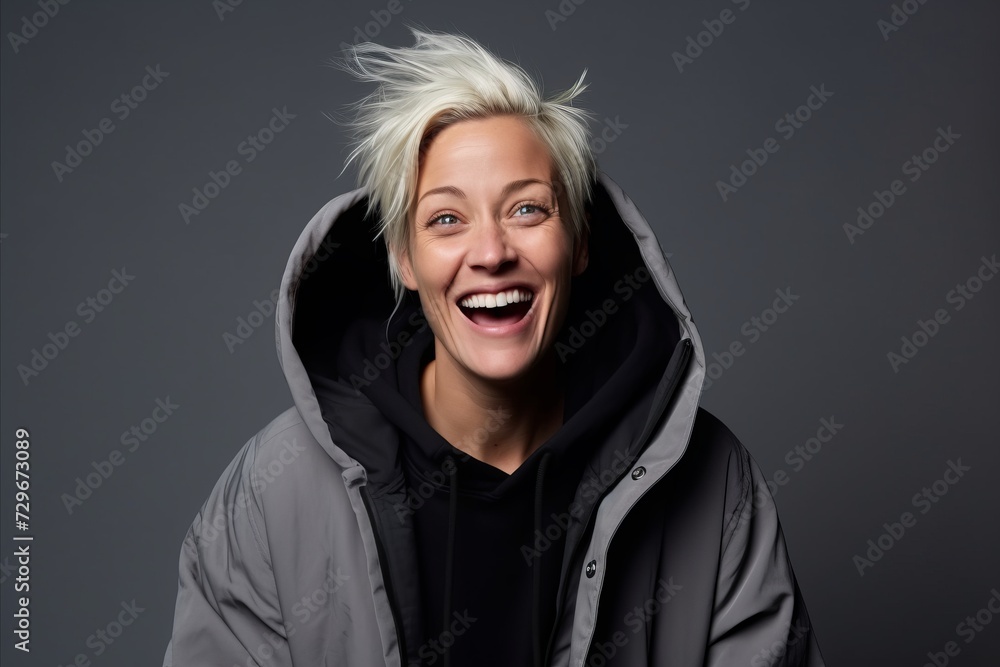 Portrait of a happy young woman laughing and looking at camera over grey background Portrait of a happy young woman laughing and looking at camera over grey background