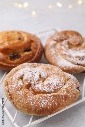 Delicious rolls with raisins and sugar powder on light table, closeup. Sweet buns © New Africa