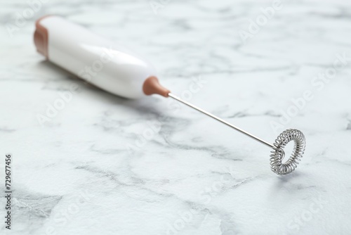 Milk frother wand on white marble table