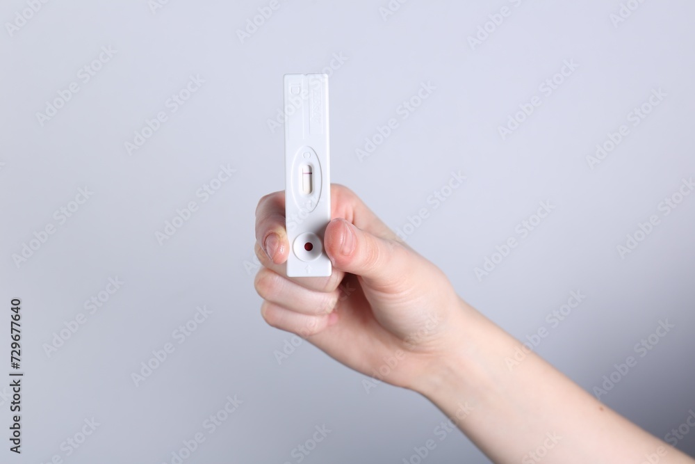 Woman holding disposable express test on light background, closeup Woman holding disposable express test on light background, closeup