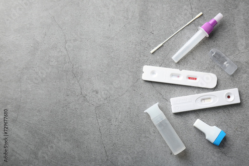 Disposable express test kits on grey table, flat lay. Space for text