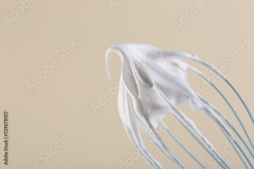 Canvas Print Whisk with whipped cream on beige background, closeup