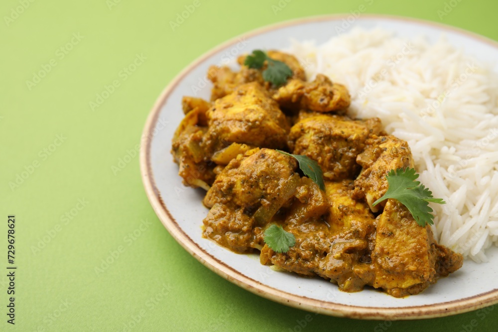 Delicious chicken curry with rice on green background, closeup Delicious chicken curry with rice on green background, closeup