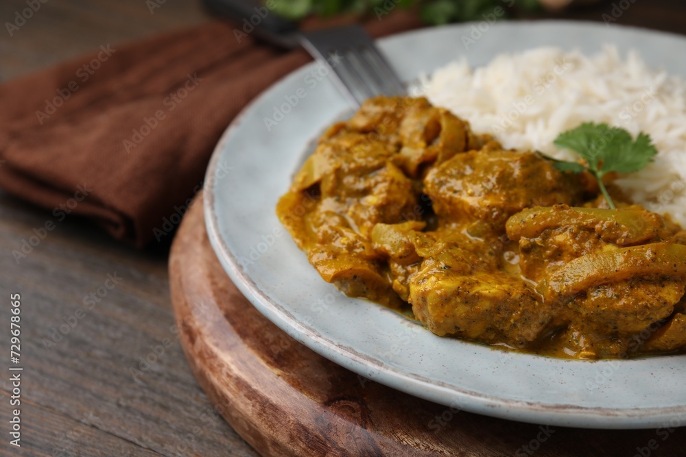 Delicious chicken curry with rice on wooden table, closeup Delicious chicken curry with rice on wooden table, closeup