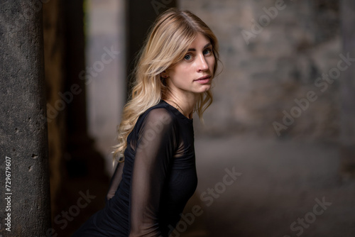 Blonde girl in black dress looking over shoulder