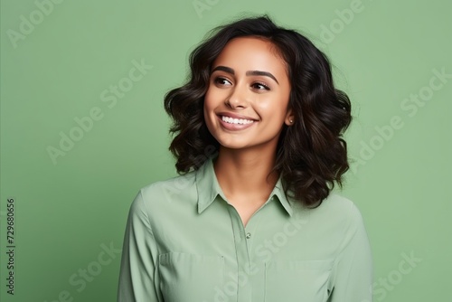 Portrait of happy smiling young beautiful brunette woman, over green background