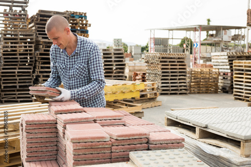 Warehouse employee puts paving slabs on a pallet