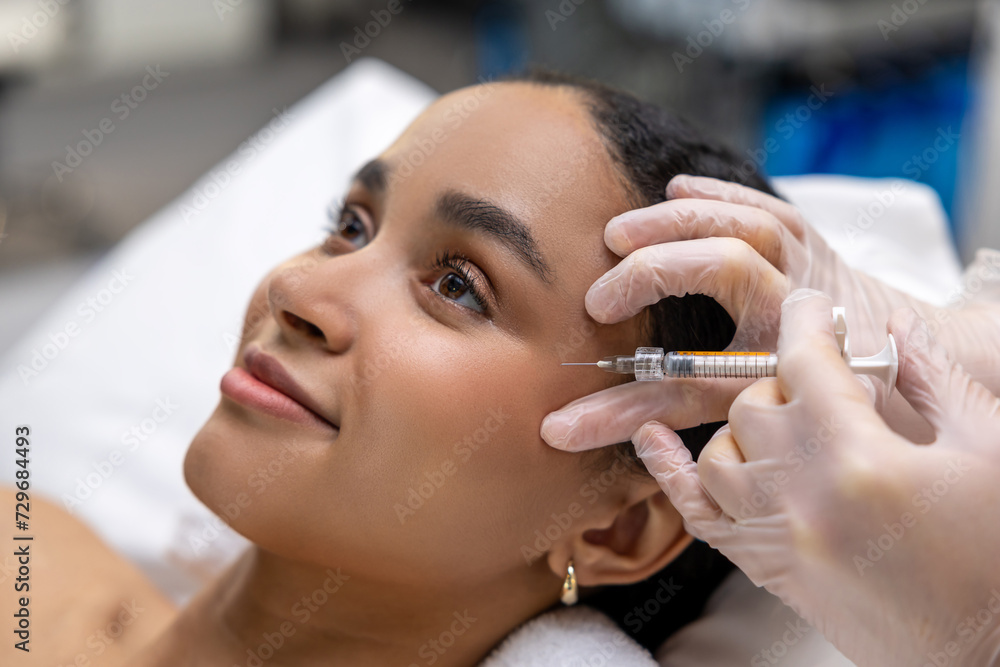 Young dark-skinned woman having a session of mesotherapy Young dark-skinned woman having a session of mesotherapy