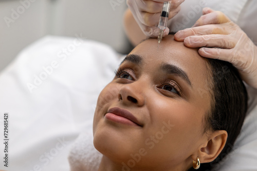Dark-haired woman having vitamin face injections at the beauty salon