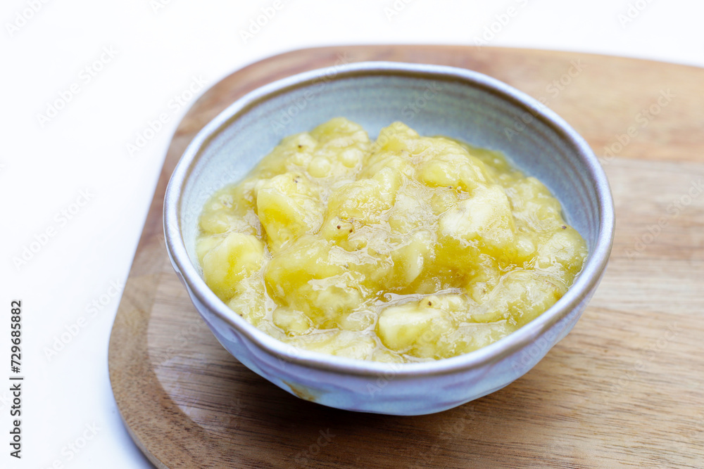 Mashed banana in bowl on white background. Mashed banana in bowl on white background.